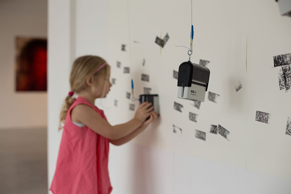 A girl stamping one of the first patterns on the wall.